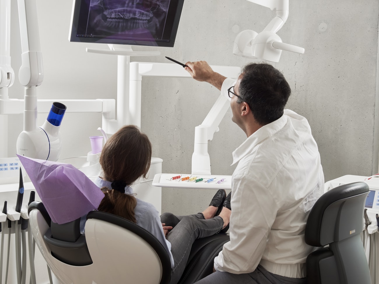 Dentista avaliando exame de imagem com a paciente